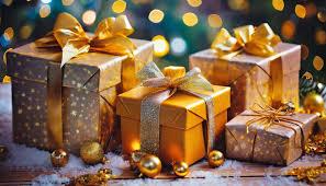 three gifts boxes with toys in varying shades of gold on a wooden table sprinkled with snow and gold holiday ornaments
